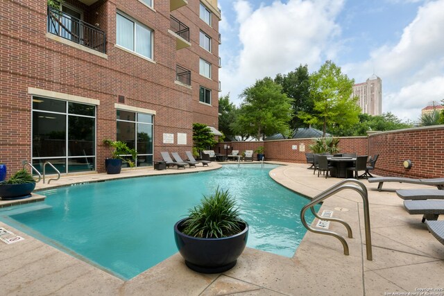 pool with fence and a patio