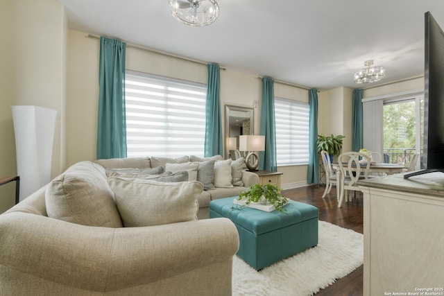 living area featuring a chandelier, dark wood-style floors, and baseboards