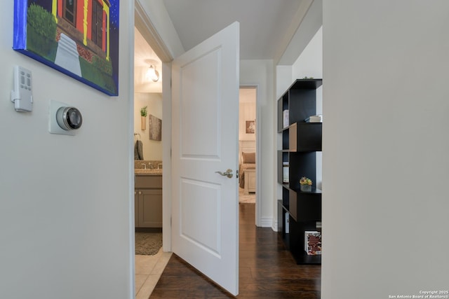 hallway with a sink and wood finished floors
