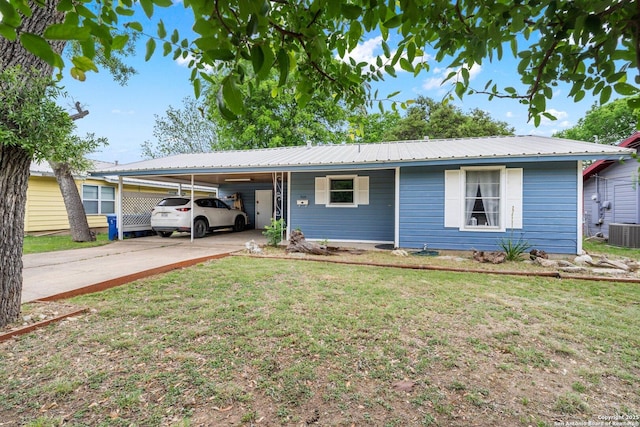 single story home with a carport, a front lawn, cooling unit, and metal roof