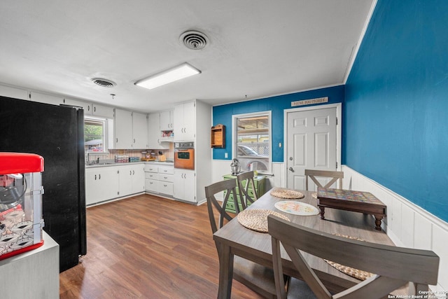 kitchen featuring wainscoting, light countertops, oven, and visible vents
