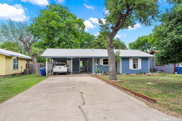 ranch-style home featuring a front yard, fence, metal roof, and aphalt driveway