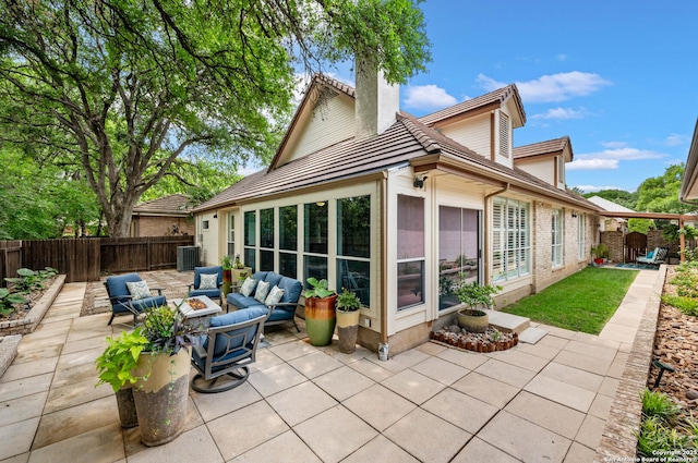 back of property featuring a chimney, a patio, outdoor lounge area, and a fenced backyard