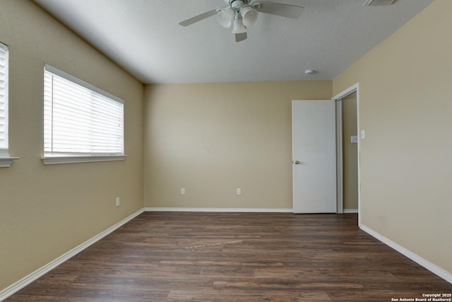 empty room with a ceiling fan, wood finished floors, and baseboards