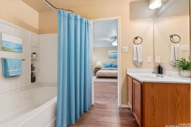 ensuite bathroom with ensuite bathroom, shower / tub combo, wood finished floors, ceiling fan, and vanity