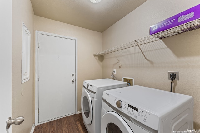 clothes washing area with washing machine and dryer, baseboards, dark wood-style floors, and laundry area