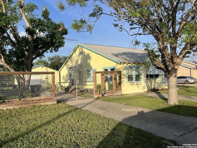 bungalow-style home with fence, a front lawn, roof with shingles, and a gate