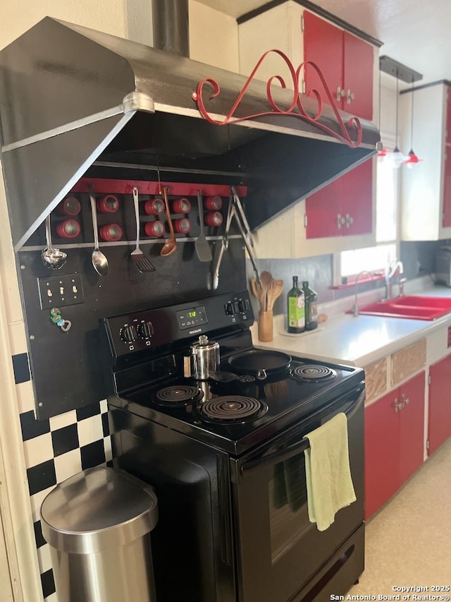kitchen featuring light countertops, a sink, red cabinets, and electric range
