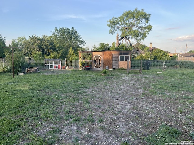 view of yard featuring an exterior structure, an outdoor structure, and fence