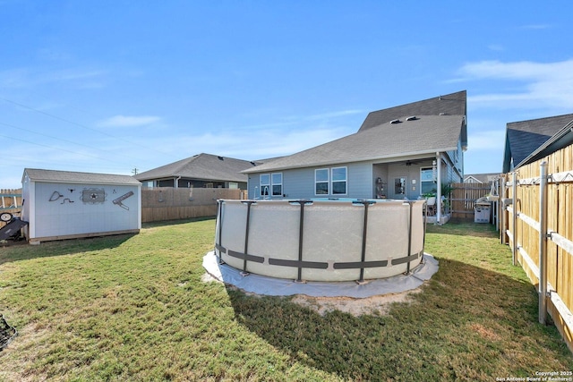 back of house with a fenced backyard, an outbuilding, a yard, and a shed