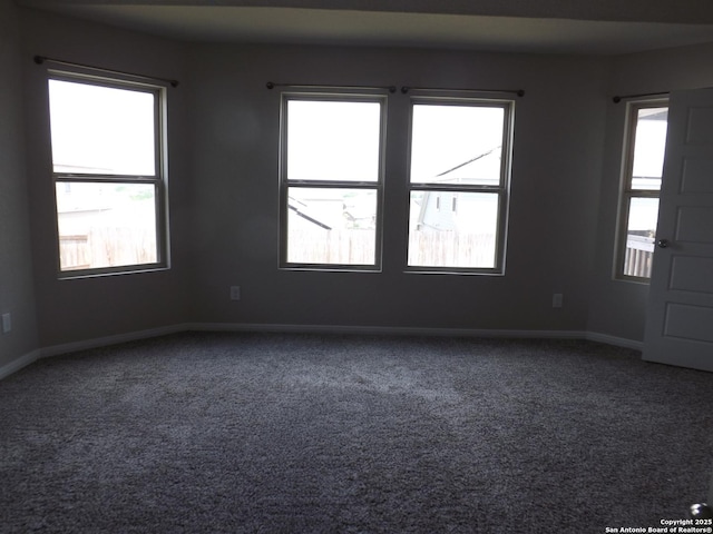 unfurnished room with carpet floors and baseboards