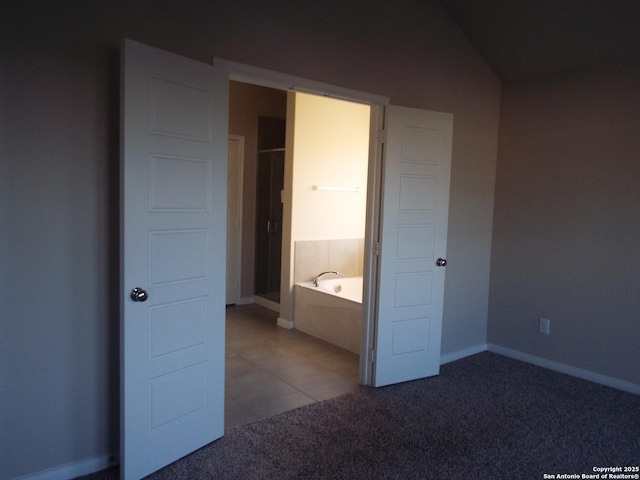 unfurnished bedroom with carpet, tile patterned flooring, and baseboards