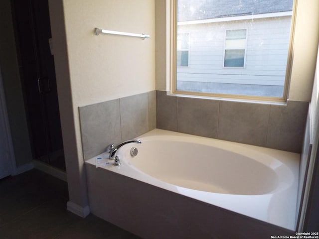 full bath featuring a shower stall, a bath, and tile patterned floors