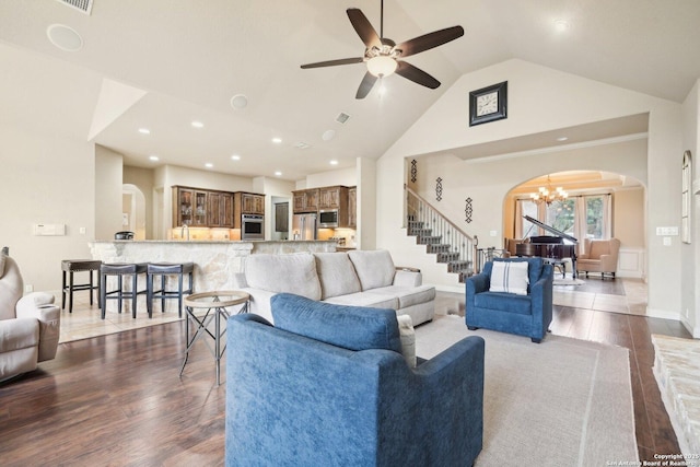 518 Ruidosa Downs, Helotes, TX 78023 - living area featuring arched walkways, ceiling fan with notable chandelier, wood finished floors, stairway, and high vaulted ceiling