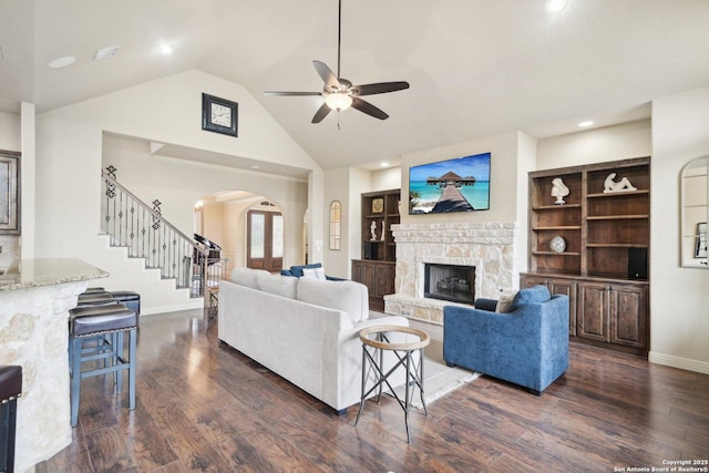 518 Ruidosa Downs, Helotes, TX 78023 - living area featuring arched walkways, dark wood-style flooring, a ceiling fan, stairs, and a fireplace
