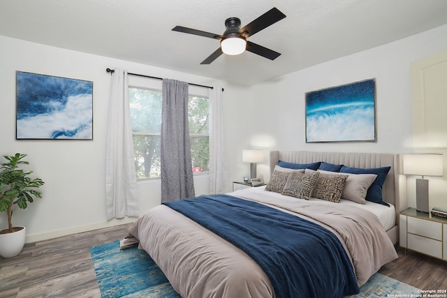 bedroom featuring wood finished floors, baseboards, and ceiling fan