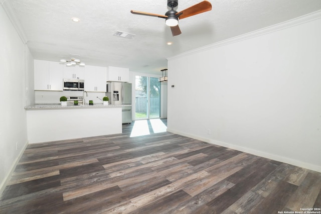 unfurnished living room with ceiling fan with notable chandelier, ornamental molding, baseboards, dark wood-style flooring, and visible vents