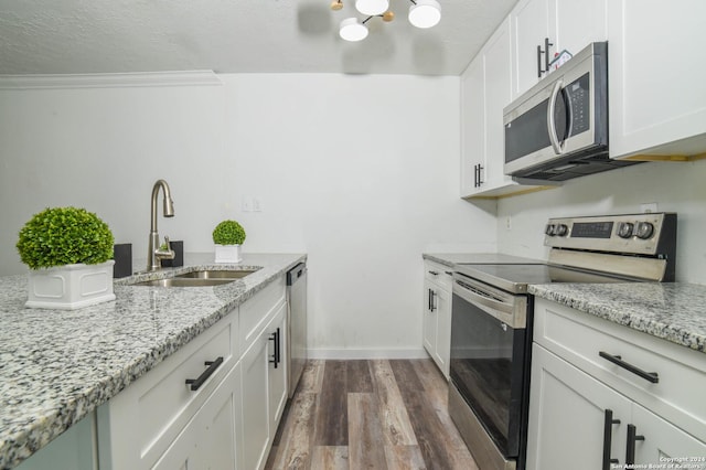 kitchen featuring a sink, a chandelier, appliances with stainless steel finishes, white cabinetry, and dark wood-style floors