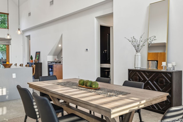 611 Simple Way, San Antonio, TX 78209 - dining area featuring visible vents, carpet, a high ceiling, and beverage cooler