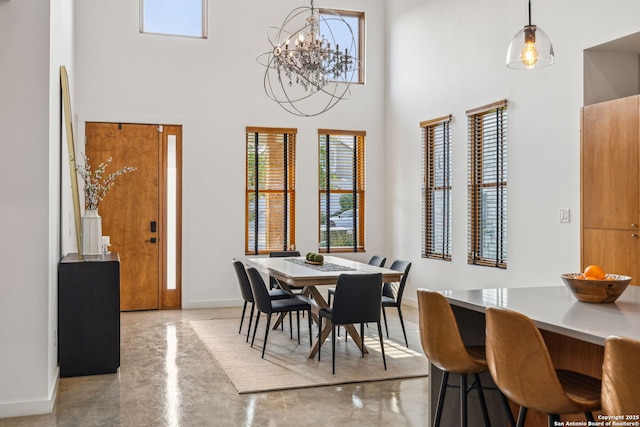 611 Simple Way, San Antonio, TX 78209 - dining area featuring a notable chandelier, baseboards, a high ceiling, and finished concrete flooring