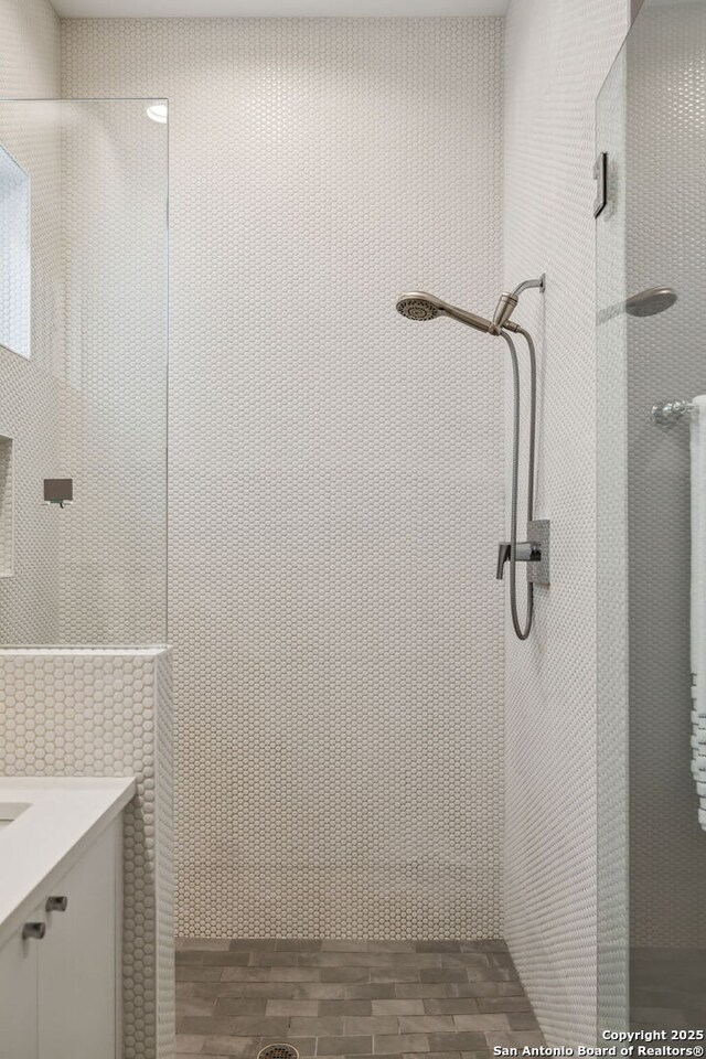 611 Simple Way, San Antonio, TX 78209 - full bath featuring tile walls, wood finished floors, vanity, and tiled shower