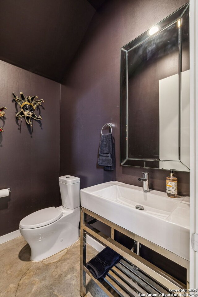 611 Simple Way, San Antonio, TX 78209 - bathroom featuring toilet, vanity, vaulted ceiling, and baseboards