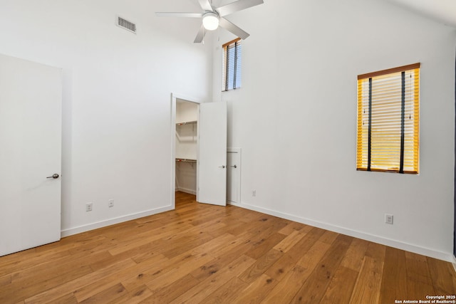 611 Simple Way, San Antonio, TX 78209 - unfurnished bedroom featuring hardwood / wood-style floors, a towering ceiling, visible vents, a walk in closet, and baseboards