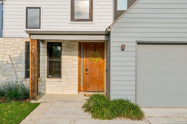 611 Simple Way, San Antonio, TX 78209 - view of exterior entry featuring stone siding and a garage