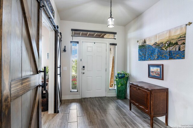5112 Arrow Rdg, Schertz, TX 78154 - entryway featuring wood tiled floor, a barn door, and baseboards