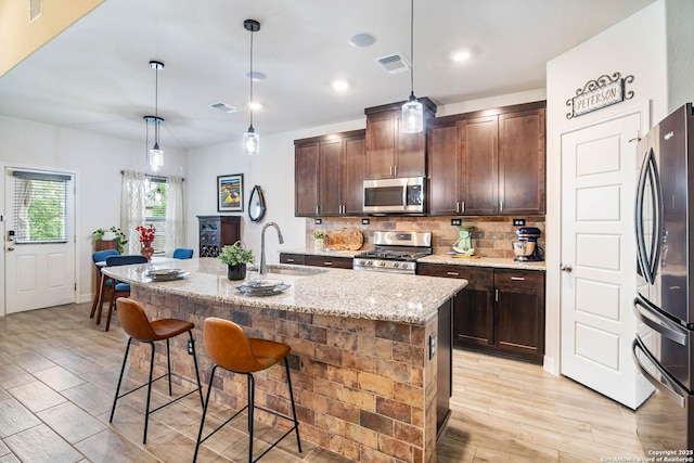 5112 Arrow Rdg, Schertz, TX 78154 - kitchen featuring decorative backsplash, stainless steel appliances, light wood finished floors, a sink, and visible vents