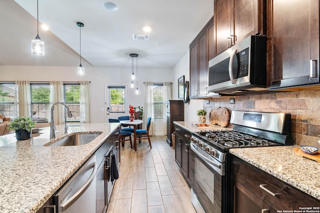 5112 Arrow Rdg, Schertz, TX 78154 - kitchen with a sink, stainless steel appliances, tasteful backsplash, dark brown cabinetry, and visible vents