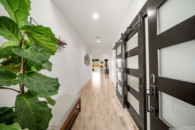 2114 Village, San Antonio, TX 78251 - hallway featuring a barn door, light wood-style floors, baseboards, visible vents, and recessed lighting