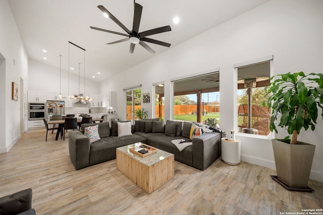 2114 Village, San Antonio, TX 78251 - living area featuring high vaulted ceiling, baseboards, light wood-type flooring, and ceiling fan with notable chandelier