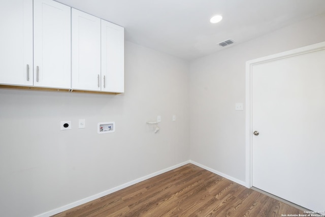 laundry area featuring hookup for an electric dryer, washer hookup, visible vents, cabinet space, and wood finished floors