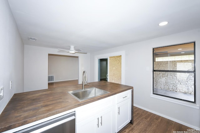 kitchen featuring wood counters, visible vents, stainless steel dishwasher, and a sink