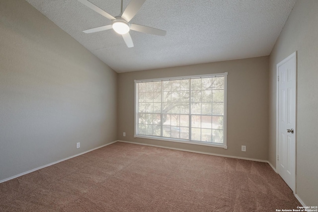 unfurnished room with vaulted ceiling, carpet floors, a ceiling fan, and a textured ceiling
