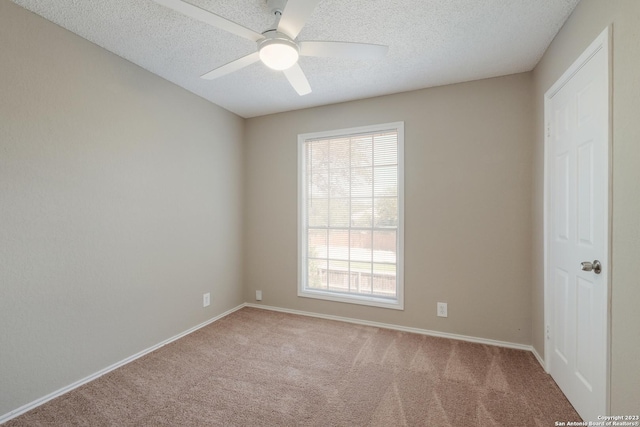 unfurnished room with baseboards, a ceiling fan, a textured ceiling, and carpet