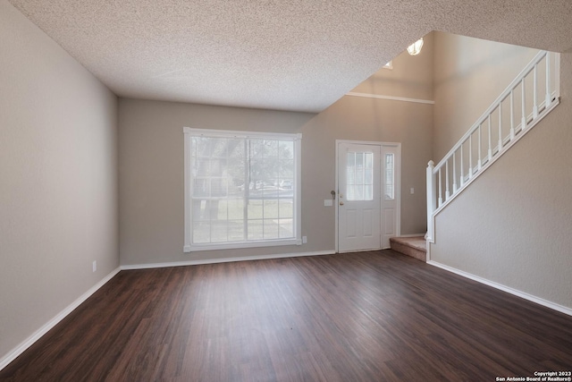 entryway with baseboards, a textured ceiling, stairway, and dark wood finished floors