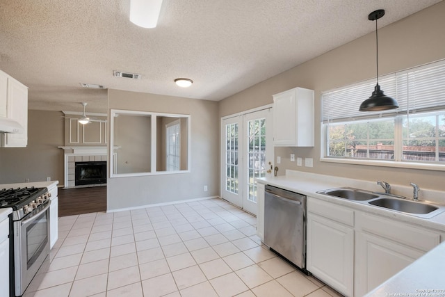 kitchen featuring stainless steel appliances, a sink, visible vents, white cabinetry, and light countertops