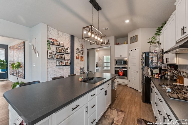 kitchen with a sink, dark countertops, visible vents, white cabinetry, and appliances with stainless steel finishes