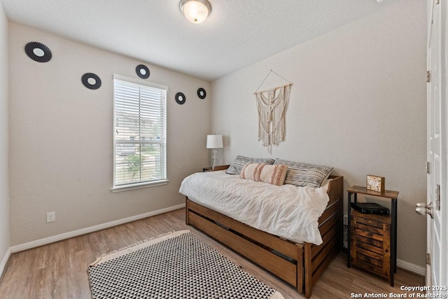bedroom with wood finished floors and baseboards
