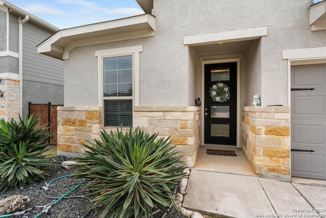 doorway to property featuring stone siding and stucco siding