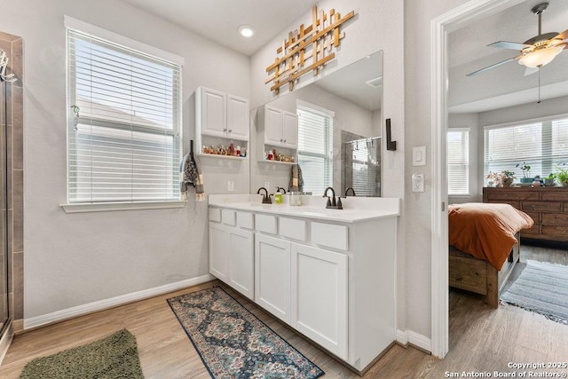 bathroom featuring ceiling fan, wood finished floors, baseboards, and a stall shower