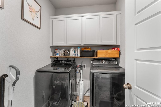 washroom with washing machine and dryer and cabinet space