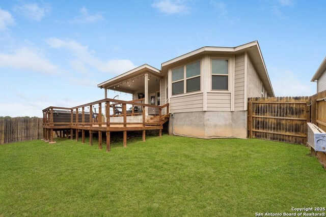back of house featuring a lawn and a fenced backyard