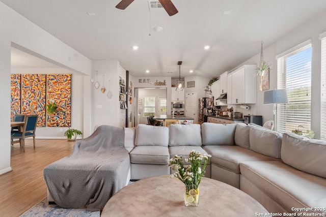 living area with light wood-style flooring, visible vents, baseboards, recessed lighting, and a ceiling fan