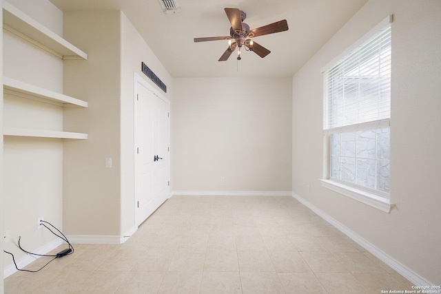 empty room with baseboards, visible vents, and ceiling fan