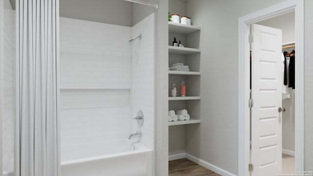 2059 Olivia Dr, New Braunfels, TX 78130 - full bath featuring wood finished floors, a spacious closet, baseboards, and shower / bathtub combination with curtain