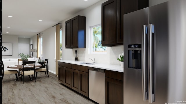 2059 Olivia Dr, New Braunfels, TX 78130 - kitchen with a sink, recessed lighting, dark brown cabinetry, light wood-style floors, and appliances with stainless steel finishes