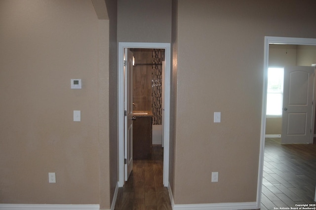 18687 Rolling Mdw, Lytle, TX 78052 - hallway featuring arched walkways, baseboards, and dark wood-type flooring